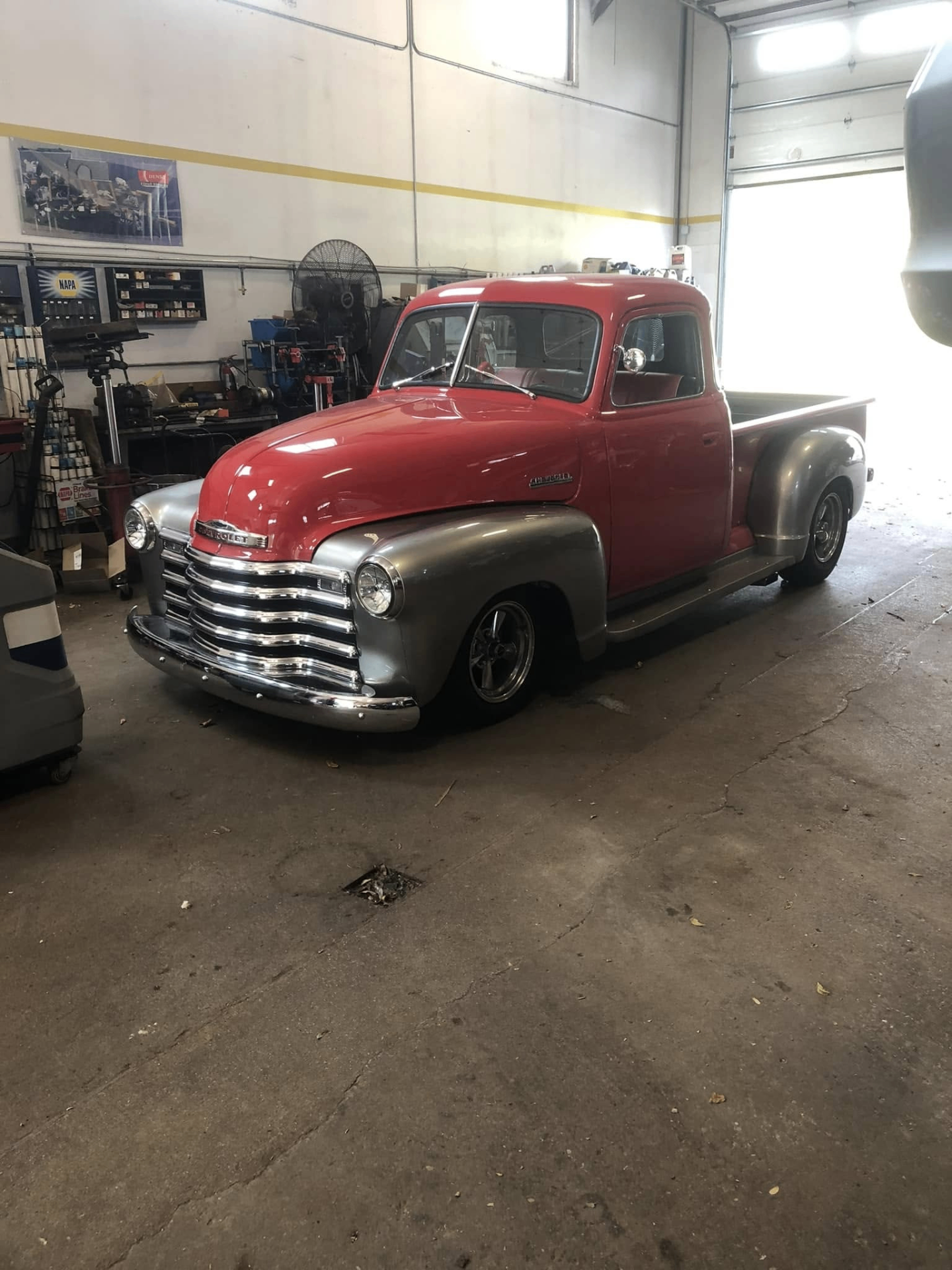 Restored red Chevrolet 3100 pickup truck in the Car Repairs Inc shop bay